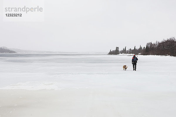 Mann mit Hund auf Süßwasser-Hafenrobbenjagd  Iliamna-See  Pedro Bay; Südwest-Alaska; Alaska  Vereinigte Staaten von Amerika