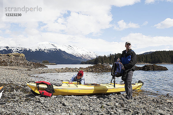 Zwei Seekajakfahrer am Ufer mit ihrem Boot  Kachemak Bay  Süd-Zentral-Alaska; Alaska  Vereinigte Staaten von Amerika