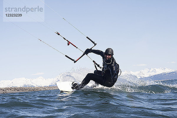 Mann beim Kitesurfen mit Kenai Mountains im Hintergrund  Homer  Süd-Zentral-Alaska; Homer  Alaska  Vereinigte Staaten von Amerika