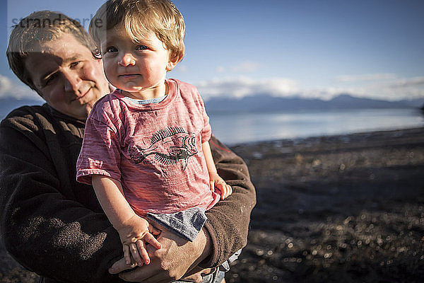 Vater hält kleines Kleinkind bei Sonnenuntergang am Strand von Homer  Süd-Zentral-Alaska; Homer  Alaska  Vereinigte Staaten von Amerika