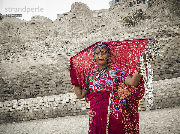 Eine Frau in farbenfroher traditioneller indischer Kleidung verkauft Schmuck  Jaisalmer Fort; Jaisalmer  Rajasthan  Indien