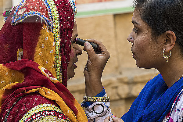 Indische Frauen beim Auftragen von Kosmetika; Jaisalmer  Rajasthan  Indien