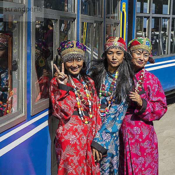 Drei Frauen in Kimonos posieren vor dem Darjeeling Toy Train  Darjeeling Himalayan Railway; Darjeeling  Westbengalen  Indien