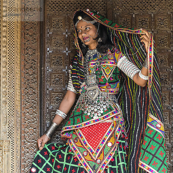 Porträt einer indischen Frau in farbenfroher traditioneller Kleidung und Accessoires; Jaisalmer  Rajasthan  Indien