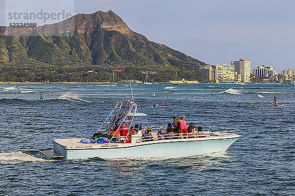 Blick auf Diamond Head  Waikiki  ein hawaiianisches Parasail-Boot und Surfen von Magic Island  Ala Moana Beach Park; Honolulu  Oahu  Hawaii  Vereinigte Staaten von Amerika