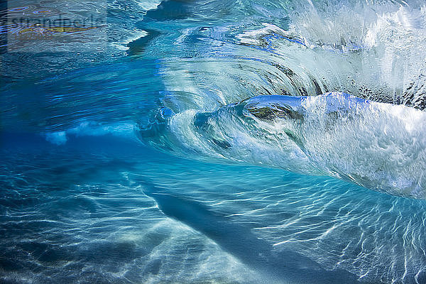 Unterwasseransicht des blauen Wassers der Brandung  die über einen sandigen Boden bricht; Maui  Hawaii  Vereinigte Staaten von Amerika