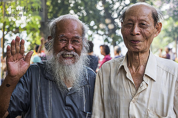 Pose älterer Männer  die lächelnd und winkend in die Kamera schauen; Hanoi  Hanoi  Vietnam