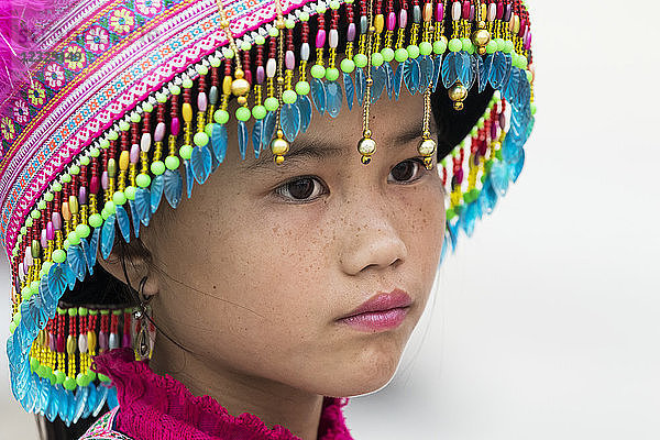 Porträt eines jungen Hmong-Mädchens  das einen bunten  dekorativen Hut trägt; Sapa  Lao Cai  Vietnam