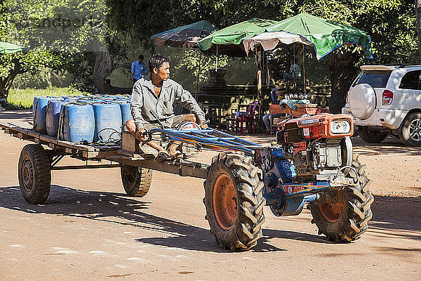 Mann fährt auf einem Traktor die Straße entlang  Beng Meala; Siem Reap  Kambodscha