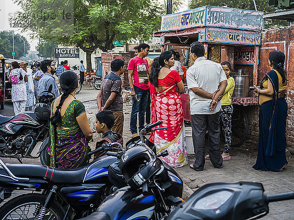 Menschen  die vor einem Verkaufsstand Schlange stehen  um etwas zu kaufen; Jaipur  Rajasthan  Indien
