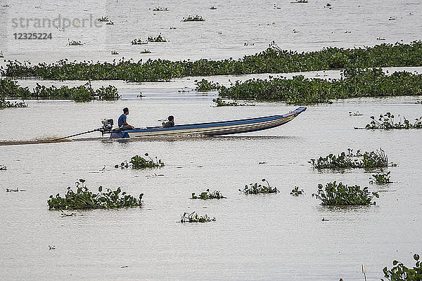 Ein junger Mann in einem Motorboot auf dem Tonle Sap; Siem Reap  Kambodscha