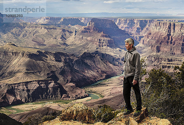 Ein älterer Mann  der im Grand Canyon wandert und auf einem Bergrücken steht und die Landschaft überblickt; Arizona  Vereinigte Staaten von Amerika