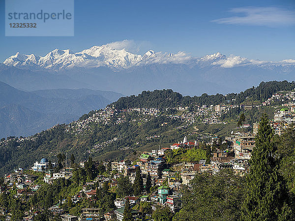 Stadt an einem Berghang mit den schroffen  schneebedeckten Gipfeln des Himalaya in der Ferne; Darjeeling  Westbengalen  Indien