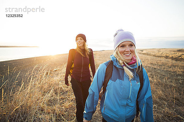 Zwei junge Frauen wandern bei Sonnenaufgang an der Küste entlang; Anchorage  Alaska  Vereinigte Staaten von Amerika