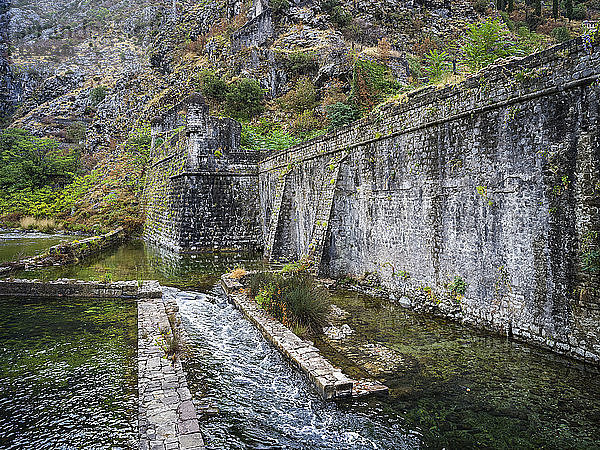 Eine abgenutzte Steinmauer mit Wasserfällen an der Bucht von Kotor; Kotor  Montenegro