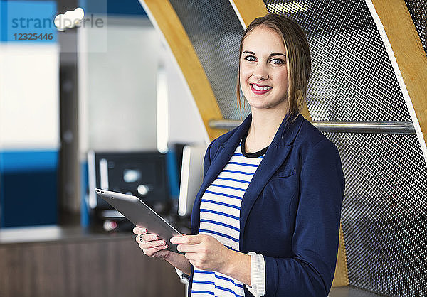 Porträt einer jungen Geschäftsfrau  die Technologie am Arbeitsplatz nutzt; Sherwood Park  Alberta  Kanada