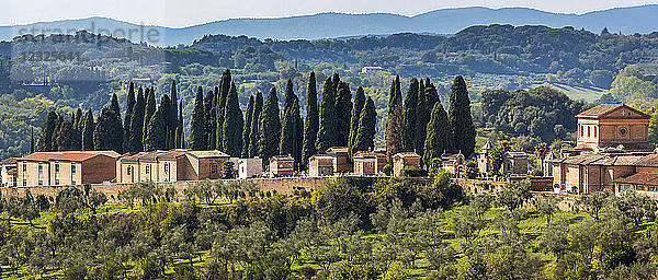 Steingebäude  Kirche und Friedhof in einer mit Bäumen bewachsenen Hügellandschaft; Siena  Toskana  Italienq