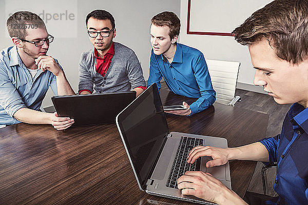 Junge Männer der Jahrtausendwende  die in einem Konferenzraum in einem modernen Hightech-Unternehmen zusammenarbeiten; Sherwood Park  Alberta  Kanada
