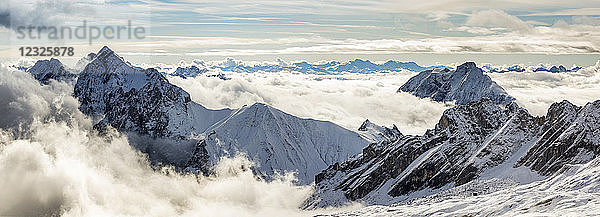 Panorama von schneebedeckten Berggipfeln mit wolkenverhangenen Gipfeln; Grainau  Bayern  Deutschland