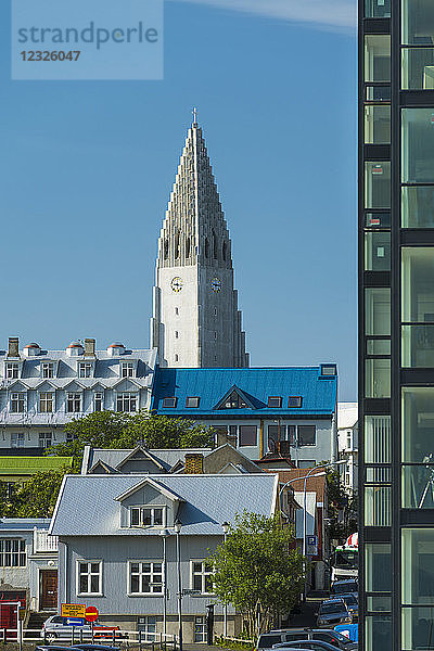 Blick vorbei an Wohnungen und Häusern auf die Hallgrimskirkja (Hallgrimur-Kirche); Reykjavik  Island