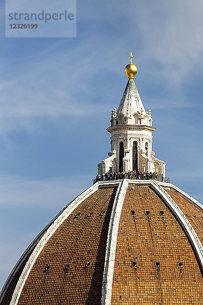 Nahaufnahme von Brunelleschis Kuppel des Doms von Florenz mit Touristen auf der Aussichtsplattform und blauem Himmel; Florenz  Toskana  Italien