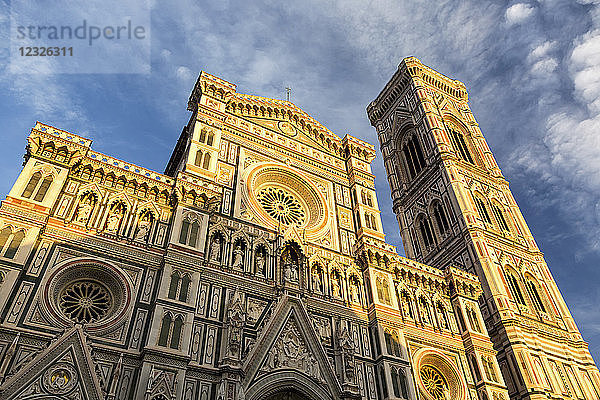 Vorderseite der Kathedrale von Florenz  warm beleuchtet bei Sonnenuntergang mit Wolken und blauem Himmel; Florenz  Toskana  Italien