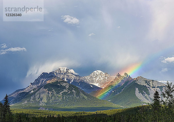 Ein Regenbogen taucht zwischen schroffen Berggipfeln während eines heftigen Regensturms auf; Banff  Alberta  Kanada