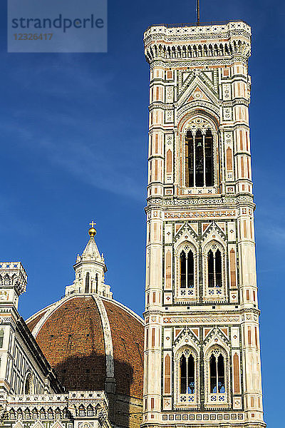 Glockenturm der Kathedrale von Florenz warm beleuchtet bei Sonnenuntergang mit blauem Himmel; Florenz  Toskana  Italien
