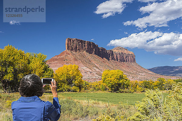 Eine Frau macht ein Handyfoto von der Felsformation 'the Palisade'; Gateway  Colorado  Vereinigte Staaten von Amerika