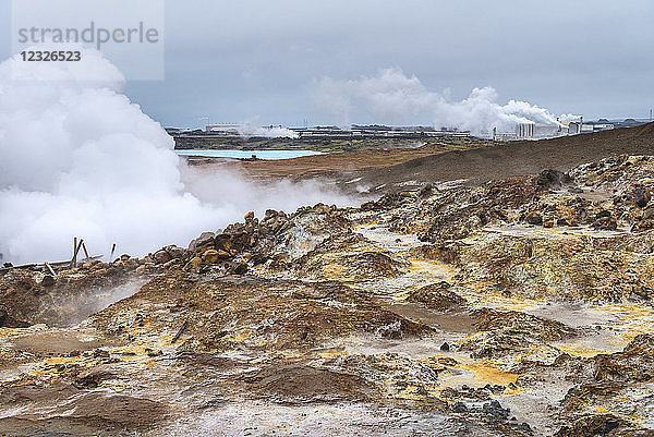 Blick über eine dampfende Mondlandschaft auf das Kraftwerk Reykjanes; Island