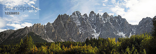 Panorama einer zerklüfteten Bergkette mit leuchtenden Bäumen im Vordergrund; Innichen  Bozen  Italien