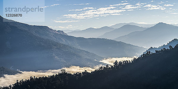 Sonnenlicht beleuchtet die tief im Tal liegenden Wolken im Himalaya; Westbengalen  Indien