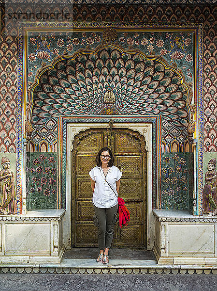 Eine Touristin steht vor dem Pfauentor  Stadtpalast; Jaipur  Rajasthan  Indien