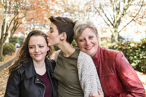 Porträt einer Mutter mit ihren beiden jungen erwachsenen Töchtern in liebevoller Pose; New Westminster  British Columbia  Kanada