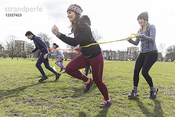 Women exercising  doing team building exercise in park