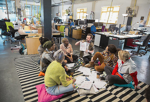 Creative business people meeting  brainstorming in circle on floor in office