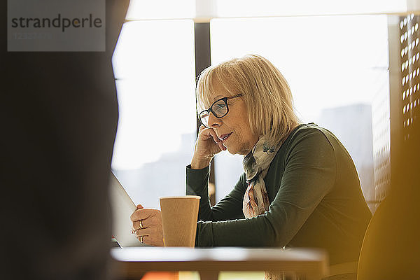 Focused senior businesswoman using digital tablet