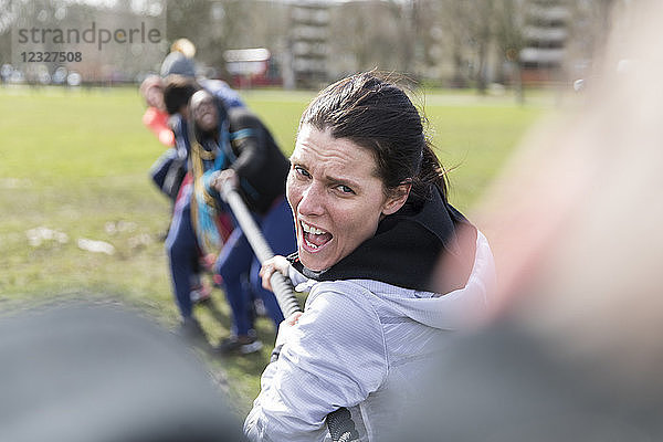 Determined woman enjoying tug-of-war in park
