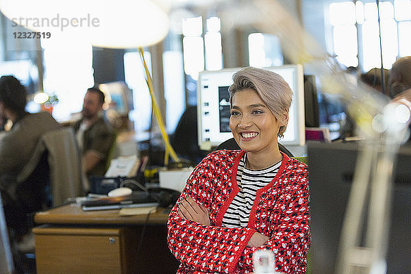 Smiling  confident creative businesswoman working in office
