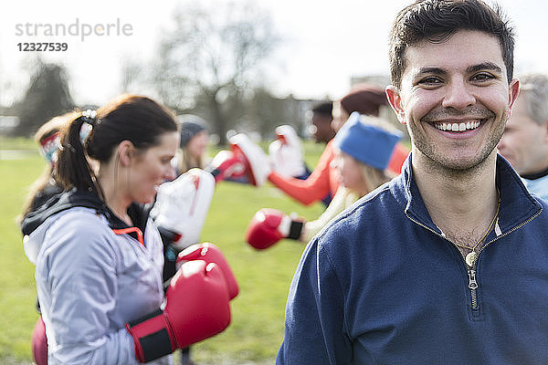 Portrait smiling  confident young man boxing in park