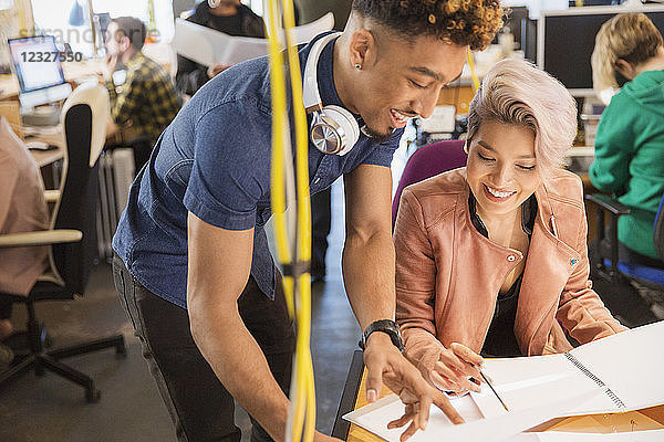 Creative business people reviewing paperwork in office