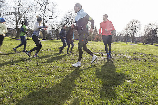 People running  exercising in sunny park
