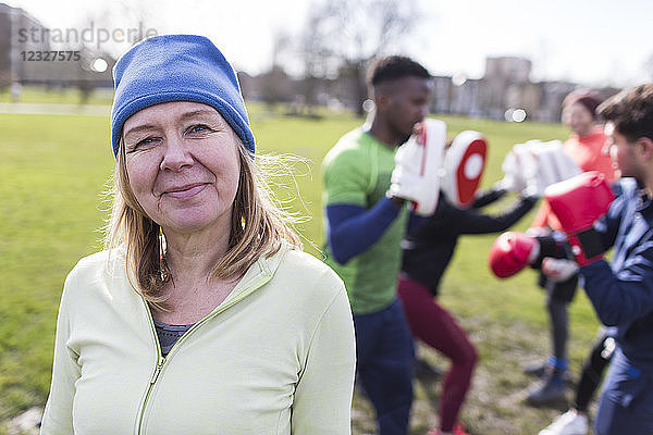 Portrait confident senior woman boxing in park