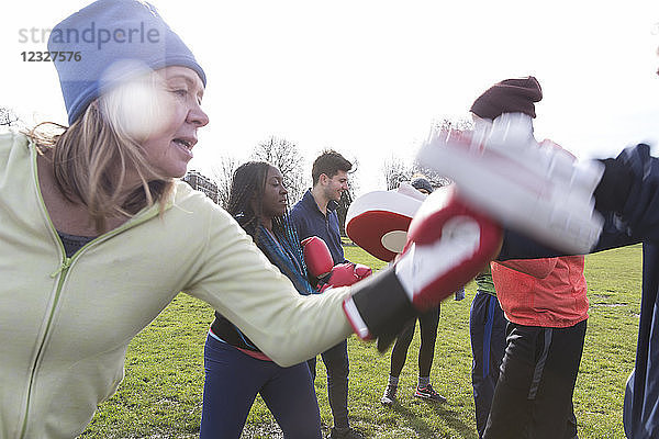 Determined senior woman boxing in park