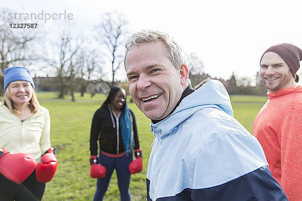 Portrait smiling  confident man boxing with friends in park