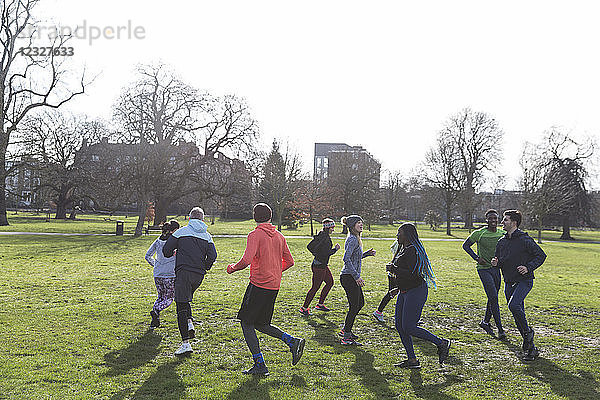 Runners jogging in circle in sunny park
