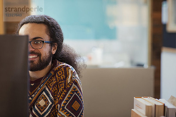 Smiling creative businessman working at computer