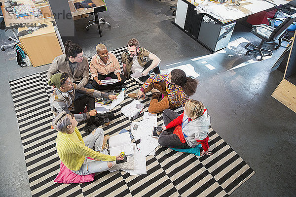 Creative business team meeting  brainstorming in circle on floor in office