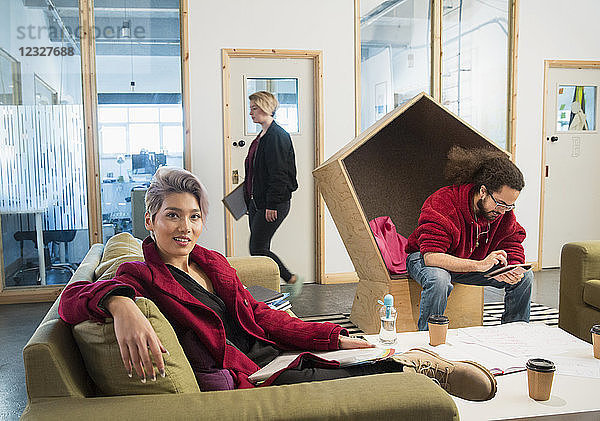 Portrait confident creative businesswoman working in open plan office