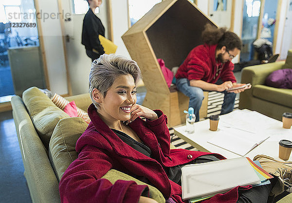 Smiling creative businesswoman with paperwork in casual office